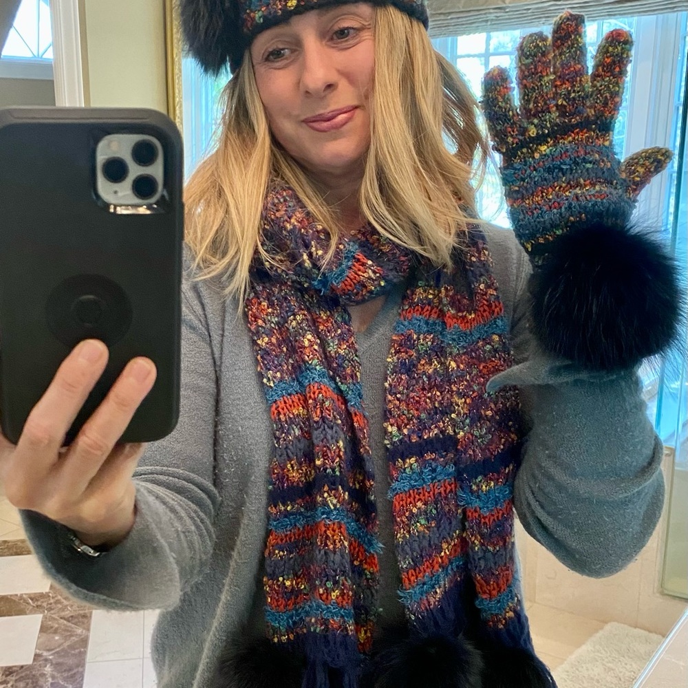 Multicolored knitted hat, scarf, and gloves with blue mink ball accents